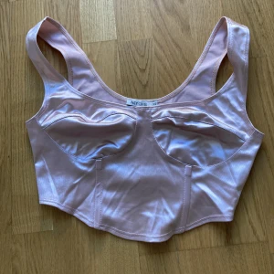 Croppad Korsett topp  - Croppad topp i korsett-stil (inte en faktisk korsett) från Nelly. Endast provat, så i fint skick. Skriv om det önskas fler bilder eller information 🌸