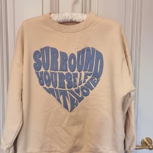 Sweatshirt  - Sweatshirt med tryck "surround yourself with love". Knappt andvänd i beige/blå färg.
