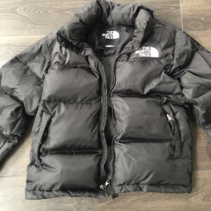 North Face Retro Nuptse jacket - Svart TNF jacka, herrmodell storlek M men mer som S. Köpt på FB förra året och nu för liten. Fint använt skick/ helhetsintryck. Litet ruggigt ställe på tyget höger axel, om man synar noga. Inget man tänker på. Skickas spårbart. 1500kr eller högre bud