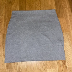 Grå kjol  - Kjol i bra skick. Slutar på låren. Rätt så tajt men inte överdrivet tajt.