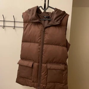Brun dunväst - Superfin brun dunväst med luva.🤎 Köpt på Shein för länge sedan. Helt oanvänd! Osäker på frakten. 