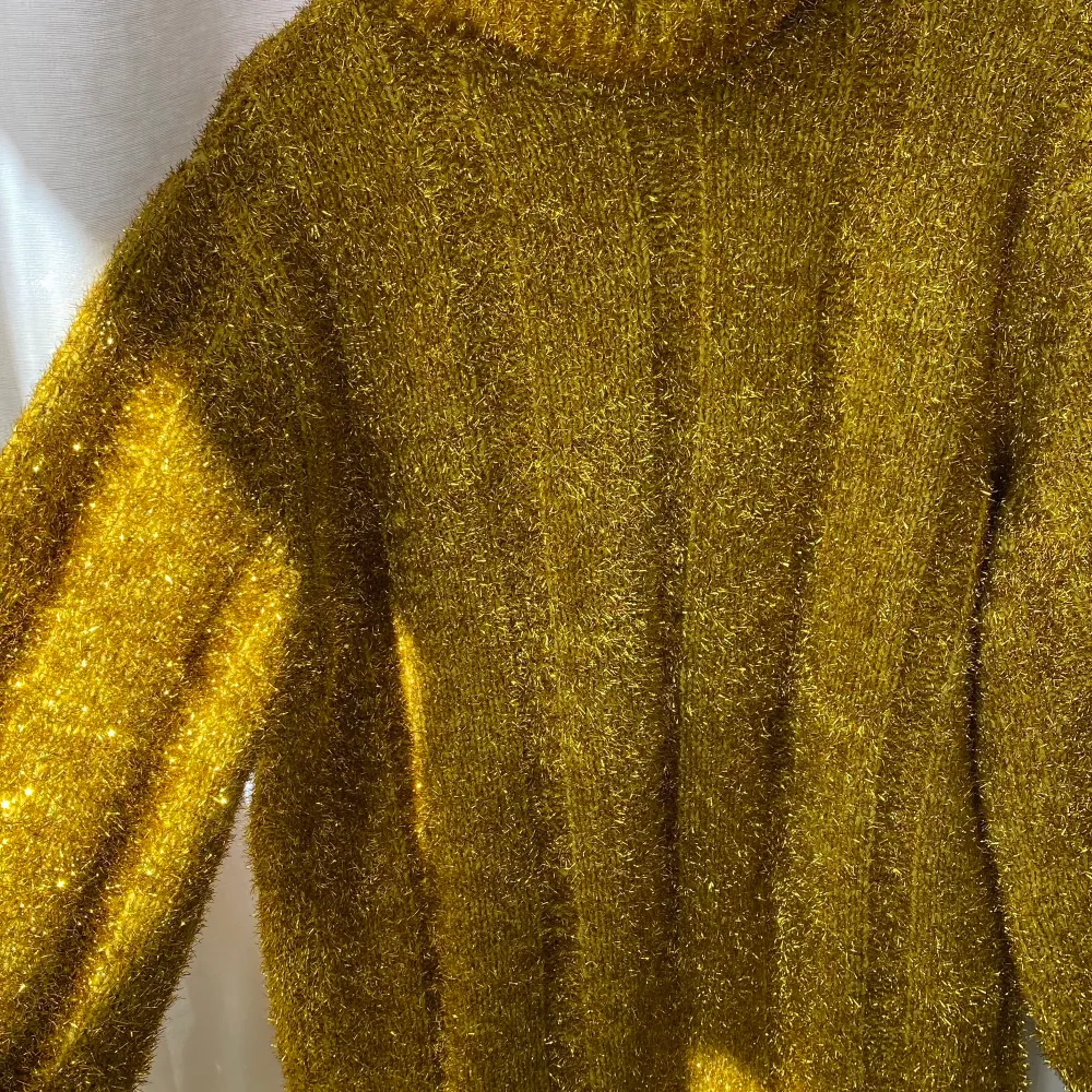 Magisk guldig stickad tröja med polo, från H&M och helt i nyskick. . Stickat.