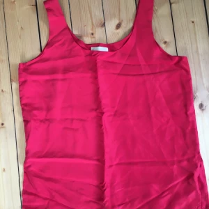 Röd sidentopp  - Jätteskönt siden.  Uppskattningsvis en L men passar fler storlekar beroende på hur man vill att det ska sitta