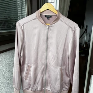 Rosa tunn bomberjacka - En tunn bomberjacka i rosa, glansigt material från Topshop. Köpt second hand men har själv aldrig använt den.