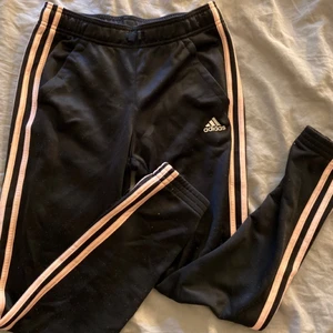 Adidas byxor  - Säljer dessa jättefina svarta/rosa adidas byxorna, köpta från Intersport i storlek 13-14 år (ca storlek 164-170). Dom är knappt använda, Nypris ca 300kr, jag säljer de för 80kr + 49kr frakt! Hör gärna av er vid intresse eller frågor!💕