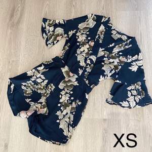 Mörkblå vacker byxdress med blad/blommönster. Från Vero Moda, storlek XS. Mycket fint skick! (Vikt 200g)
