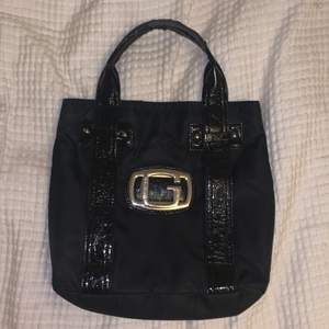 en handväska från guess köpt secondhand i färgen svart
