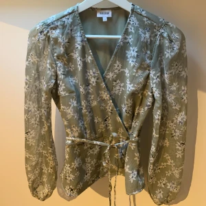 Blommig blus - Söt blus med knytband i midjan. Aldrig använd, xs.