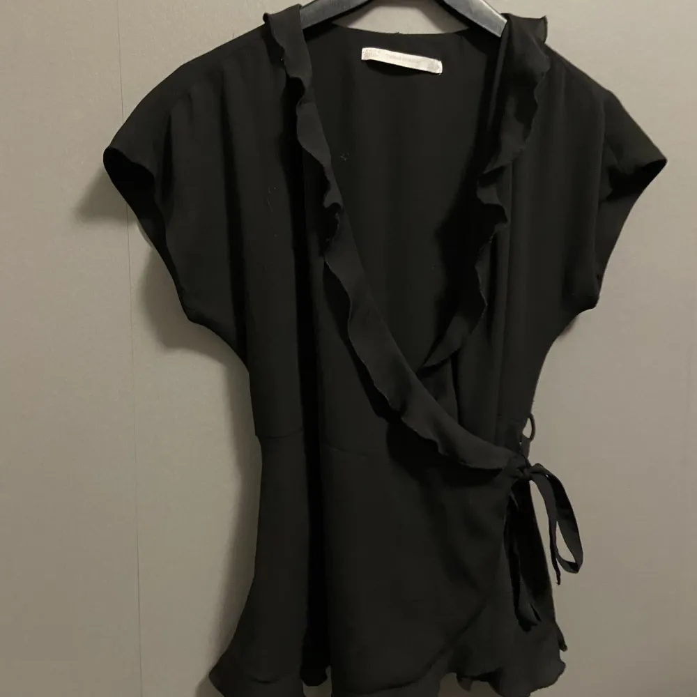 En svart blus/kofta med fina volanger och fin knytning Från Zara Säljer endast för att den är för liten Aldrig använd. Blusar.
