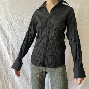 Svart veckad skjorta - Svart veckad skjorta, lång i ärmarna. 