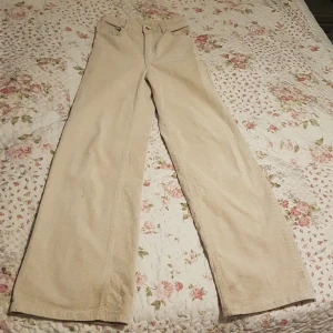 Beiga byxor - Knappt använda byxor från h&m med utsvägningar från knäna Lågmidjade