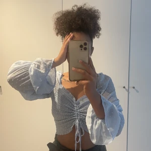 Söt topp/blus - Jätte söt topp i babyblå tunt material men inte genomskinlig vid brösten