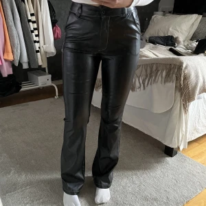 Skinnbyxor med vit kontrastsöm  - Supersnygga skinnbyxor med vit kontrastsöm. Byxorna är i storlek XS i längd 33. Dem är ifrån Madlady och har inga fickor där bak