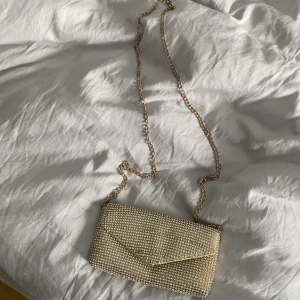 Guldglittrig liten väska  - Från glitter o använd vid 1/2 tillfällen. Fattas några få  stenar men inget som märks. Nypris ca 300kr💛