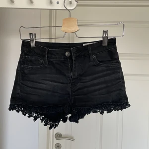 Jeansshorts  - Svarta snygga jeansshorts från Crocker med en spetsliknande tygvolang i kanten. Säljer pga att jag har råkat köpa två par likadana. På sista bilden har jag på mig de andra likadana fast i storlek Xs