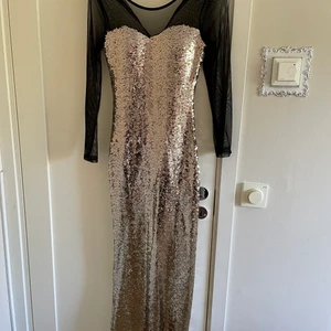Fest klänning guld/svart - Ny festklänning i storlek S Guldig/svart  Ingen dragkedja utan endast en knapp.  