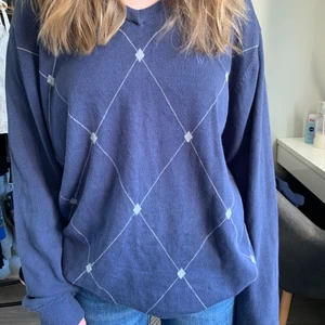 Thriftad långärmad tröja  - Mörkblå mönstrad tröja. Tunt ish stickat material. Storlek L men sitter ändå inte för pösigt som ni kan se på bilden. Väldigt skönt material. Använt skick men inga defekter.