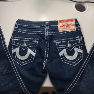True religion jeans - Supersnygga lågmidjade mörkblåa true religion jeans med vit sömn i storlek 25!💓 om fler vill ha dem så blir det budgivning, bud på 460kr!