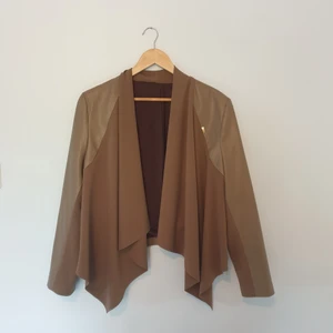 Ljusbrun Läderjacka - En fin läderjacka utan fickor, med dekorativa dragkedjor på sidorna.  Storlek 38 100% polyester