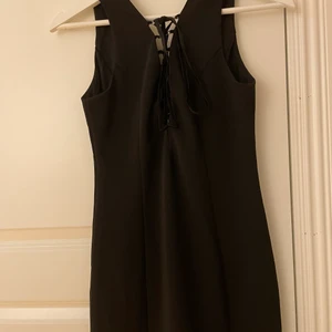 Svart klänning med öppning vid brösten - Nytt skick. Svart klänning med öppning vid brösten