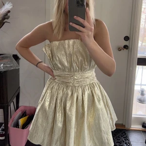 Oanvänd cool klänning - Supersnygg klänning i guld/champagne-färg. Storlek 38 men passar även mig som har 36. Helt slutsåld och jag har aldrig använt den så den har alla lappar kvar. 