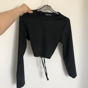 Fest topp - Snygg festtopp i ”slinky” material med öppen rygg. Stretchig & man kan välja hur tight den ska sitta med hjälp av knytningen där bak. Aldrig använd😌