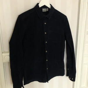 Manchesterskjorta - Mörkblå skjorta i manchester. Köpt på ASOS, aldrig använd. Storlek S, herrmodell men fungerar bra unisex. Kraftigt och snyggt tyg. 