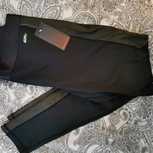 Tights - Svarta tights med guldig rand på sidorna. Oanvända med lapp kvar. 