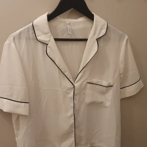 Blus från MANGO - Vit blus med svarta detaljer. Knappar framtill. 