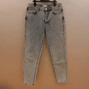 Dagny mom jeans från Ginatricot i stl 40 - Säljer dessa "dagny mom jeans" från ginatricot I stl 40. Jeansen har hög midja och blixtlåsgylf. De är oanvända och mycket fina jeans, säljes pga att de är för stora för mig. 