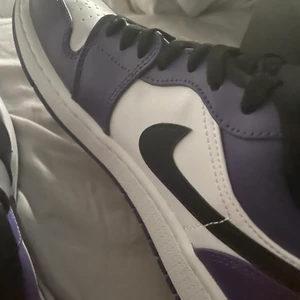 Air Jordan 1  - Säljer mina nu nästen helt nya och oanvända Air Jordan 1 lila low, de är i väldigt väldigt sparsamt skick, man får med kartong, rengöring och skydds papper i skon. Använda 1 enda gång, sedan dess varit i kartongen. Säljes pga för stora för mig! Strl 40,5 men passar 37-39. Inga defekter förutom vid tån (se bild) nypris- 1900kr, mitt pris- BUDGIVNING I KOMMENTARERNA! Först TILL KVARN, kan mötas upp annars skickas de, då står köparen för frakten! 😀