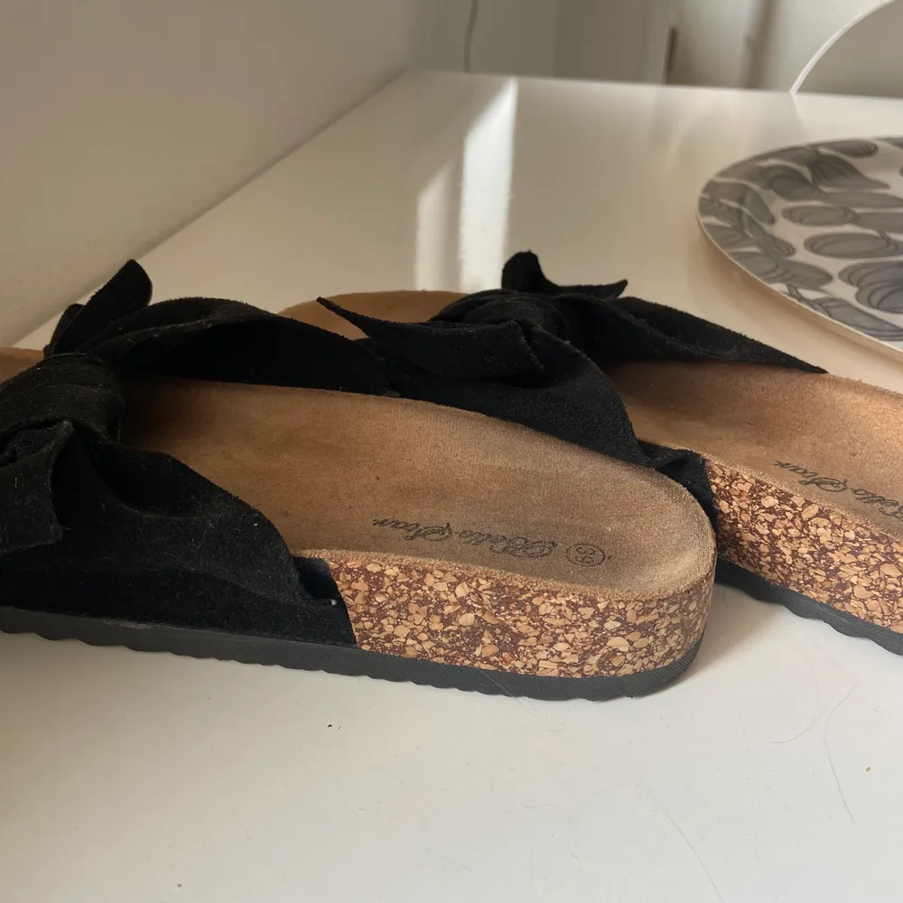 Ett par svarta sandaler med rosett från bello star . Skor.
