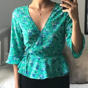 Blommig omlott topp - En omlotttopp från H&M som jag aldrig använt. Knyts runt med ett band.