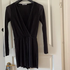 Långärmad shortsdress  - Svart - ribbad - långärmad shortsdress från Gina Tricot. Knäpps med hacke (se bild 3) vid bröstet.  Väldigt skön material. Funkar både till vardag och fest. Oanvänd. 