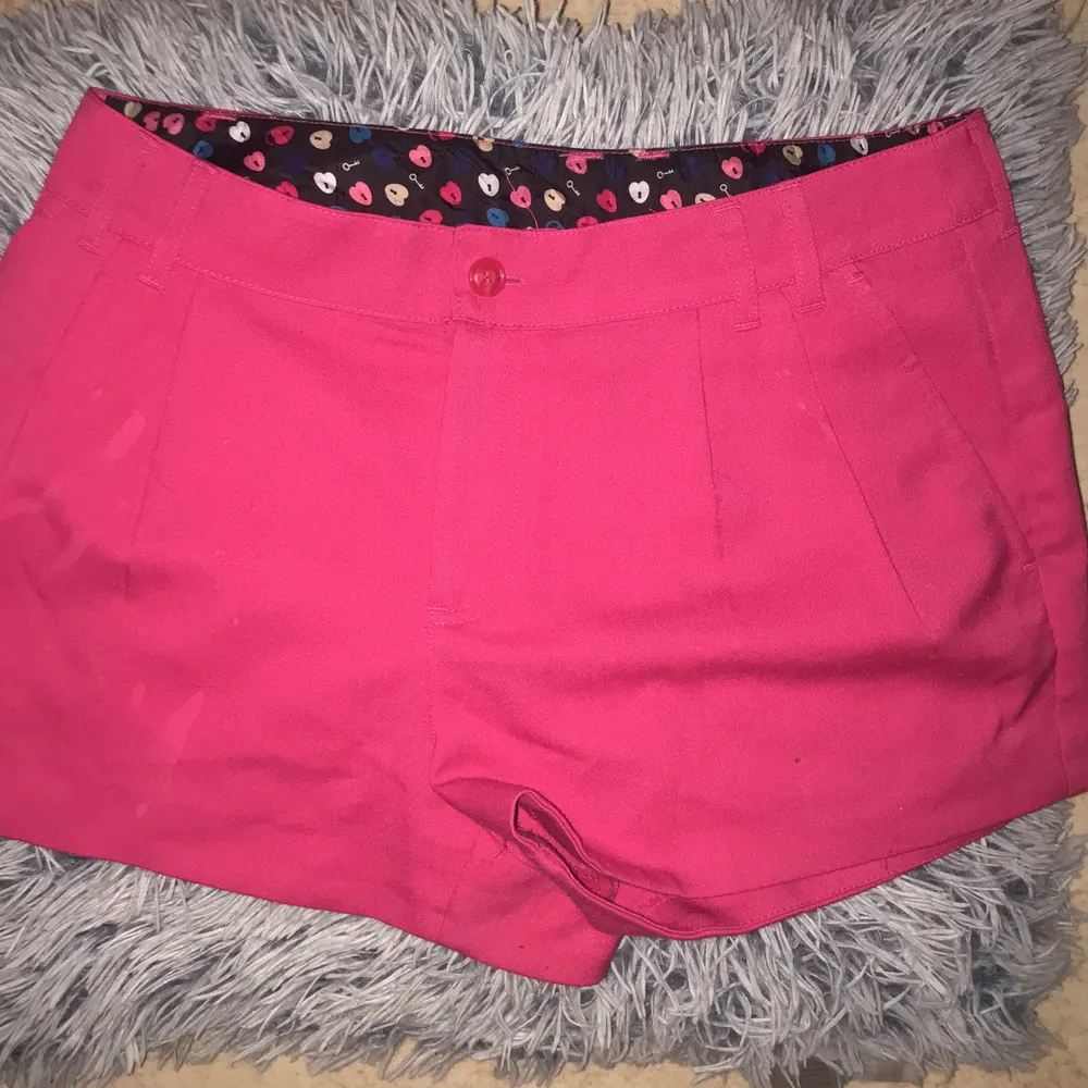 Rosa shorts i finare material. Fickor finns både fram och bak; de bak är fortfarande ihopsydda (kan sprättas upp).  Nästan helt oanvända. . Shorts.