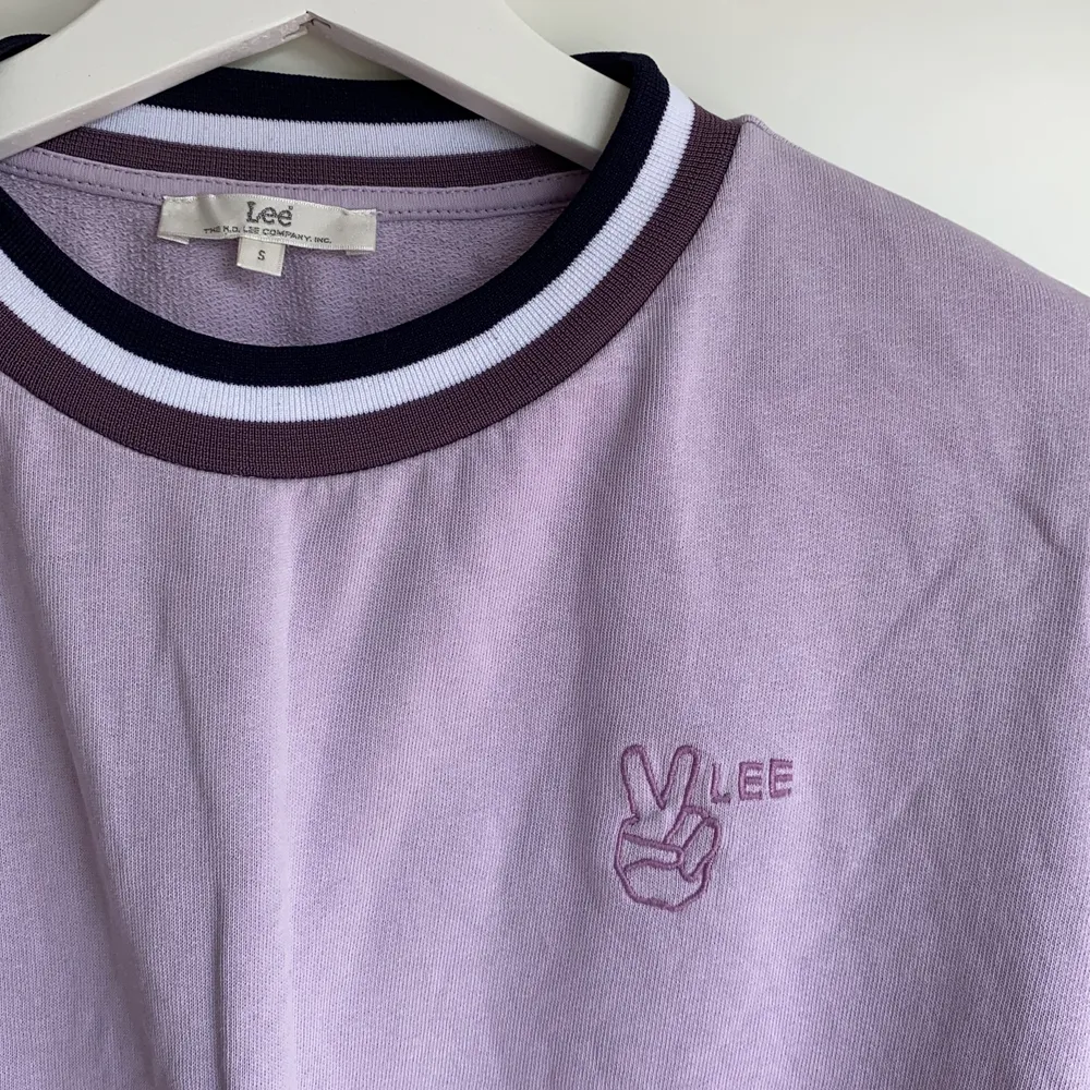 En ljuslila sweatshirt från märket Lee som är tryckt med ett lila ”peace sign”. Väl använd och därför säljer jag den för ett bättre pris. Priset går att diskuteras.. Tröjor & Koftor.