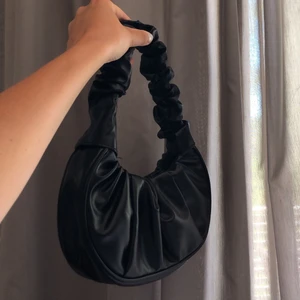 Svart väska  - Säljer denna super snygga svarta axelväska pga att den aldrig kommit till användning! Helt oanvänd.