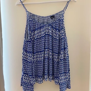 Blå topp - En blå topp med ”tomma axlar”. Tunnt och luftigt tyg.