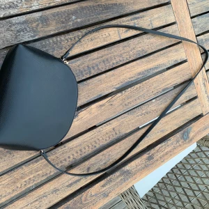 Svart handväska från hm - Super fin liten svart väska med gulddetaljer från hm. Den är 24x19cm. Aldrig använd. Frakt- 62kr💖💖