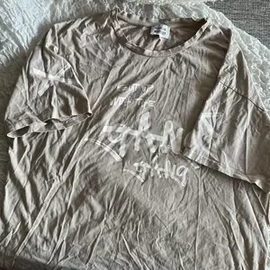 oversize T-shirt från RIBECKA X MADLADY, storlek XL. Ljusbeige med tryck på ärmarna och bröstet. 