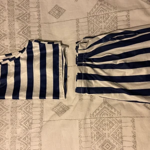 Set - Ett snyggt set i vita och mörkblåa ränder. Toppen är kroppad och byxorna är högmidjade. Är i mjukt, luftigt och skönt material, perfekt till sommaren. Byxorna ser stora ut på bild men är inte lika stora i verkligheten. Säljer toppen för 50kr och byxorna för 100kr. Kontakta vid interesse eller frågor💕