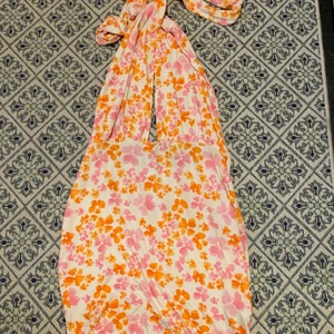 Blommig klänning - Halterneck klänning från ASOS Design. Man kan knyta banden olika för olika stilar men min favorit är halterneck! Stretchigt material så passar M-XL