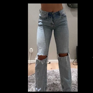 Jeans - Säljer dessa supersnygga jeans i tvättad blå färg med hål på knäna. Säljer då de inte kommer till användning och att jag själv tycker att de är lite korta (jag är 172cm). De är i strl 38 men skulle säga att de passar som en liten 38 eller en 36. De är använda men ändå i toppskick, utan slitningar osv. Inga fler hål utom på knäna och ett litet på fickan. Kan antingen fraktas eller mötas upp i Sthlm.