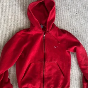 Nike zip up hoodie  - En väldigt snygg röd zip up hoodie från Nike. Säljer pga att den inte kommer till användning. Det är bara lite noppror på. Buda privat.