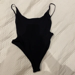 Svart baddräkt med öppen rygg - Svart baddräkt med öppen rygg från Pö Swim by Ava Frati i storlek S. Aldrig använd! 