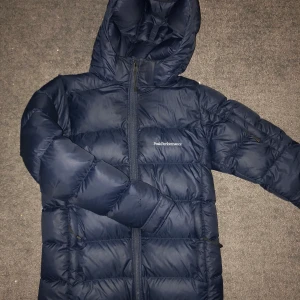 Peak performance dunjacka - Mörkblå dunjacka från peakperformence i stl 160 (kids size) (passar xs) använd en halv vinter och väl omskött så den är i fint skick. Säljer pga att jag tröttnat på modellen. Varm och skön och klarar vintern i Norrland. Nypris 2500kr