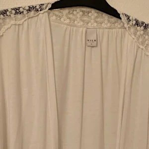 Kofta med vida armar  - Vid kofta med vita armar och spets. St: L. Aldrig använd 