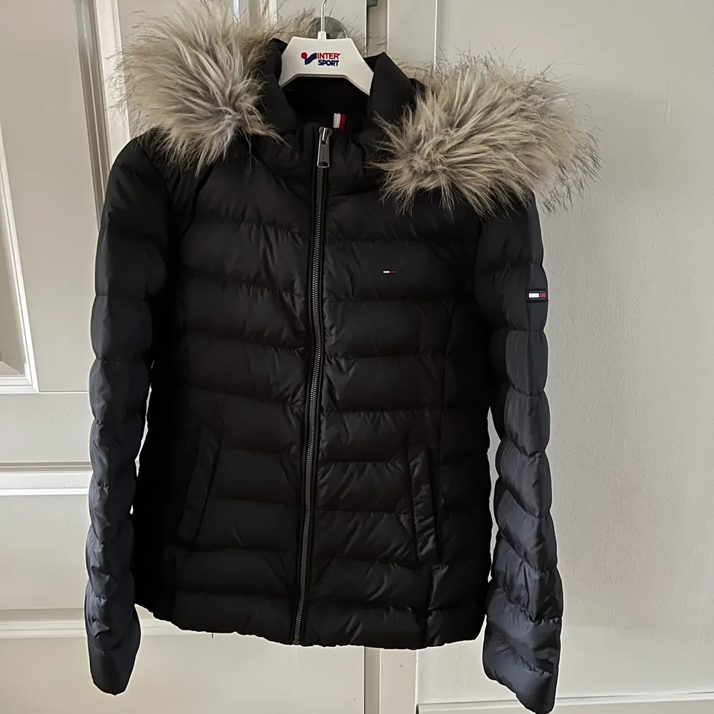Säljes Tommy Jeans Hilfiger basis hooded jacket vinterjacka svart stil M men passar S-M. Endast använd en vinter säsong. I nyskick, behöver ”puffas” upp lite då den hängt i garderob. Avtagbar huva och pälskrage.  Nypris 2595kr. . Jackor.