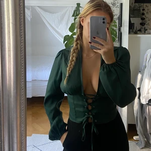 Corset top - Supersnygg helt ny grön blus i korsett stil från Boohoo. Sitter väldigt smickrande på kroppen och går att justera framtill🥑🫑 frakt tillkommer!