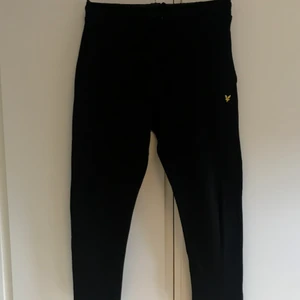 Lyle and Scott mjukisbyxor - Mjukisbyxor Lyle and Scott, Svarta 12/13 år. Med dragkedja nere i benet och en ficka på höger bak ben. Knappt använda, bra skick.